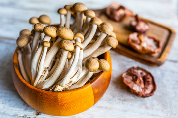 Fresh Shimeji and Shitake mushrooms on a wooden background.