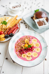 pink porridge with banana and berries on a white background. tasty porridge with fruits. healthy breakfast