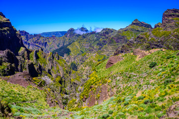 Beautiful hiking trail from Pico do Arieiro to Pico Ruivo, Madeira island. Footpath PR1 - Vereda do Areeiro. On summy summer day above the clouds. Portugal.