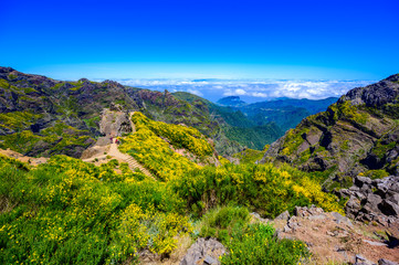 Obraz premium Beautiful hiking trail from Pico do Arieiro to Pico Ruivo, Madeira island. Footpath PR1 - Vereda do Areeiro. On summy summer day above the clouds. Portugal.