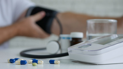 Image with a Person Checking His Blood Pressure with a Modern Electronic Medical Device