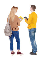 Back view of couple in sweater with mobile phone.