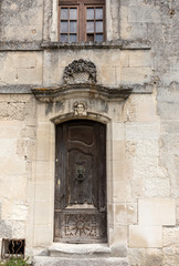 Old wooden door on stone  house  in Les Baux de Provence, France
