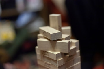 Tower of wooden blocks. Who will win and not drop more than one detail. A game for a fun company. The development of accuracy and fine motor skills. Wooden set of identical boards.