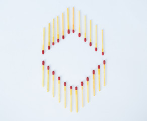 Two opposite directed row of matchsticks arranged as a frame on a white background