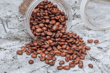 aromatic coffee beans dropped out of a glass jar