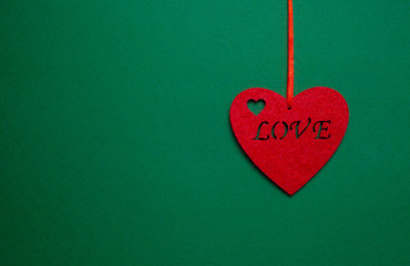 Decorative heart with the inscription love on a green background