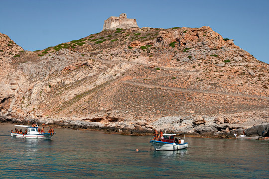 Some boats with tourists on board visit the rocky coast of the island of Marettimo, in the Egadi islands in Sicily, Italy.