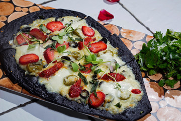 Activated charcoal pizza with toppings