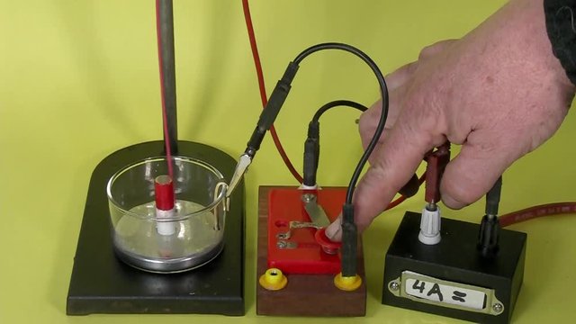 Faraday motor with mercury pool and a conducter that moves in circles around a magnet when a current flows.