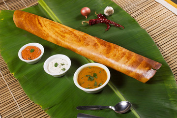 Masala dosa on banana leaf with both sambar and coconut chutney. South Indian Vegetarian Snack