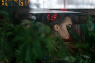 horizontal photo through the glass of a young woman sitting at a cafe table
