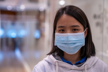 Fototapeta na wymiar A women wearing a dust mask PM2.5,Corona virus,Corona 2020,Portrait Asian children girl wear N95 mask to protect PM 2.5 dust and air pollution.