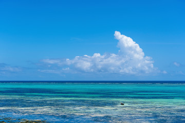 White beautiful clouds and blue sky over sea water waves on the island of Zanzibar, Tanzania, Africa. Travel and nature concept