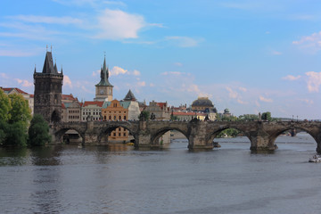Charles bridge (Karluv most) over Vltava river, Prague, Czech Republic. Summer day. Blue sky with few clouds.