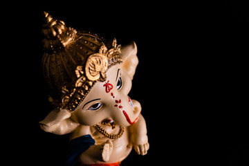 top angle view of beautiful ganesha statue giving blessing with black background. culture and...
