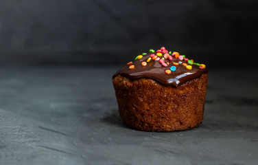 Pumpkin cake sprinkled with chocolate ganache, decorated with colored pastry decoration