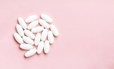 white circle from tablets and pills isolated on pink background with sunlight.