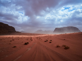Fototapeta na wymiar Beautiful Scenery Scenic Panoramic View Red Sand Desert and Ancient Sandstone Mountains Landscape in Wadi Rum, Jordan during a Sandstorm