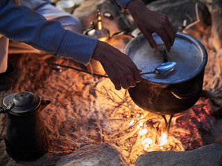 Bedouin man cooking traditional bedouin meal on fire in a tent