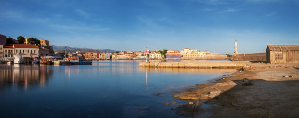 Naklejka premium Panoramic view of Old harbor of Chania with the lighthouse and fortification at sunrise, Crete, Greece