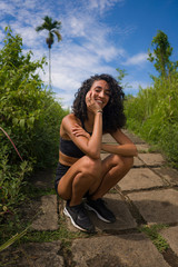 Summer holiday lifestyle portrait of young attractive and happy tourist woman in fitness clothes walking carefree exploring beautiful ridge walk  at Ubud in Bali island