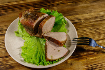 Tasty baked pork with spices on a wooden table