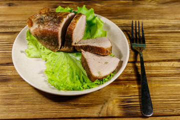 Tasty baked pork with spices on a wooden table