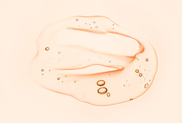 Photo of cream gel orange transparent cosmetic sample texture with bubbles isolated on white...