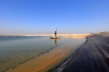 Fishermen patrol boats in aquaculture ponds on a farm, Luannan County, Hebei Province, China