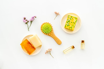 Coconut, argan and jojoba oil for hair. Set with brush on white background top-down