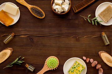 Hair care concept. Coconut oil, brush on dark wooden background top-down frame copy space