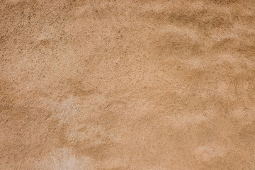 The texture of the wall is made of sand-yellow brick flooded with sunlight. Stains on the wall decorated with yellow sand.