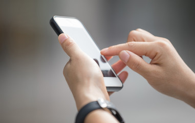 Hands using smartphone in modern city