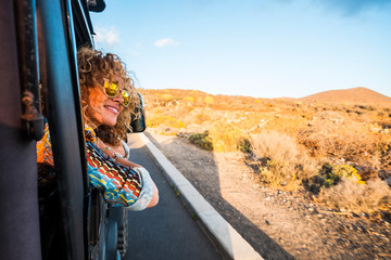 Happy beautiful free modern caucasian woman travel on the road with a car - transport and people...