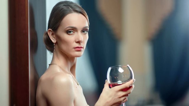 Close up sexy naked woman posing holding bocal of wine. Shot on RED Raven 4k Cinema Camera