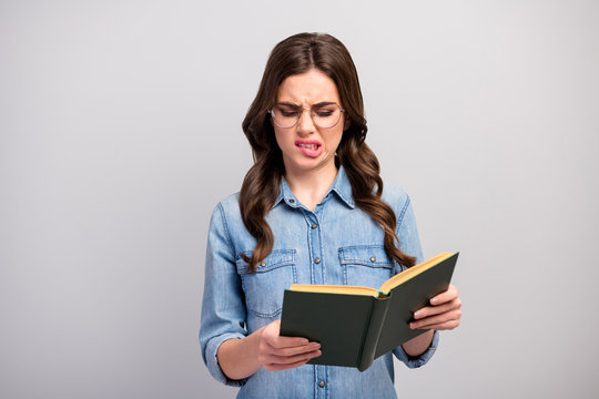 Ugh. Photo of pretty business lady hold book hands reader bad mood read disgusting chapter grinning wear specs casual jeans denim shirt isolated grey color background