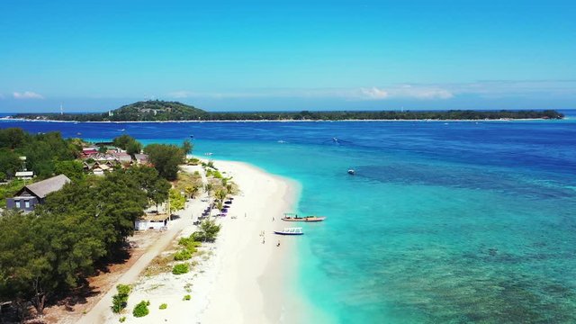 Idyllic vacation destination with hotels and villas near exotic beach washed by calm clear water of turquoise lagoon in Indonesia