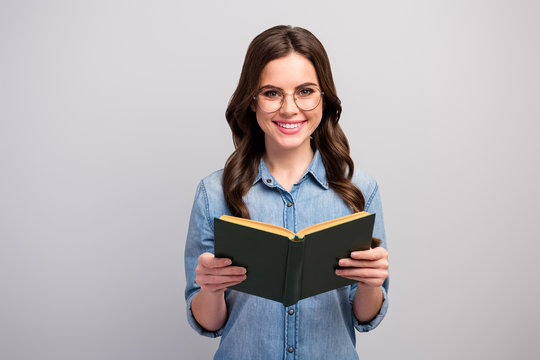 Photo of pretty funny business lady hold book hands reader toothy beaming smiling good mood wear specs casual jeans denim shirt isolated grey color background