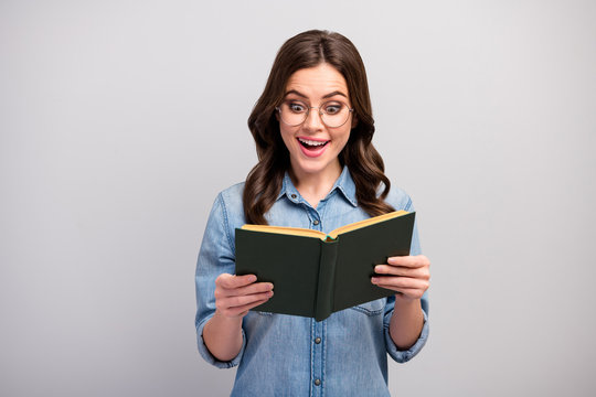 Photo of pretty funny business lady hold book hands addicted reader book worm amazing exciting happy ending wear specs casual jeans denim shirt isolated grey color background