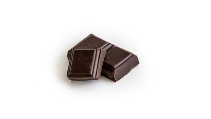 three dark chocolate pieces on a white background. Isolated. 
