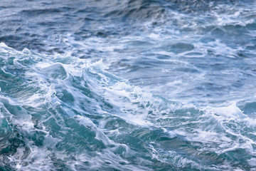 Fototapeta na wymiar White crest of a sea wave. Selective focus. Shallow depth of field