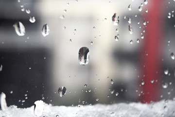 Fototapeta na wymiar Raindrops on window, raindrops from snow in winter
