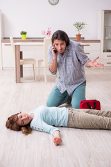 Young couple in first aid concept at home