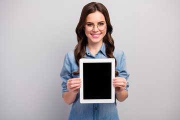 Photo of beautiful freelancer lady hold e-reader tablet demonstrating new gadget model sale low price wear specs casual jeans denim shirt isolated grey color background