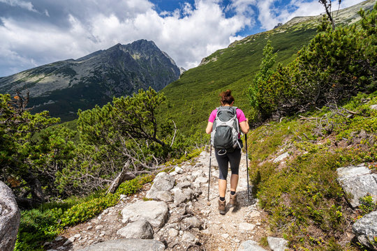 Young woman on a mountain terrain trail. Hiking in High Tatras National Park, Slovakia.