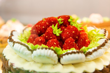 Confectionery decoration, cream strawberries on the cake. Red cream strawberries in a marshmallow basket