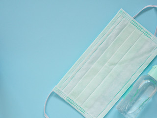 Medical face mask with alcohol gel in bottle on blue background, Health care and Medical concept..