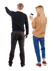 Back view of couple couple in sweater pointing.