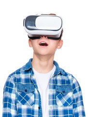 Happy teen boy wearing virtual reality goggles watching movies or playing video games, isolated on white. Cheerful teenager looking in VR glasses. Funny child experiencing 3D gadget technology.